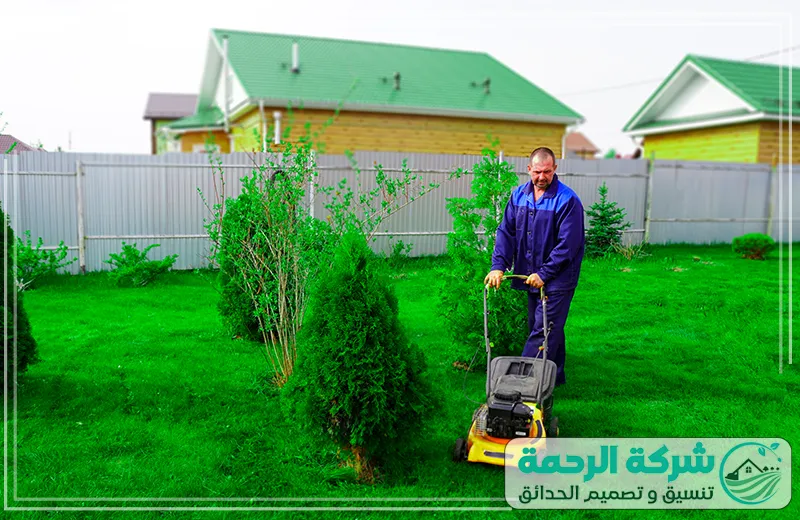شركة تنسيق حدائق بيشة الجنوب خدمات جز العشب 0559460943 شركة الرحمة عامل من شركة الرحمة يقوم بجز العشب في الحديقة باستخدام ماكينة جز العشب