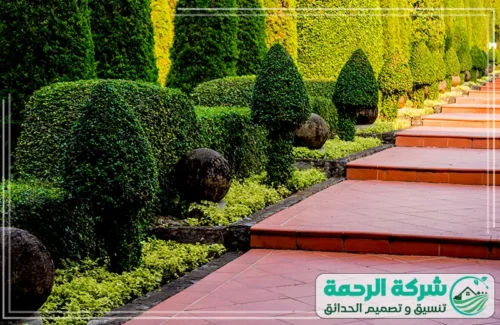 تنسيق حدائق فلل بخميس مشيط 0559460943 الرحمة جلسة خارجية مريحة تحت مظلة محاطة بزهور ملونة وتنسيق حدائق عصري.