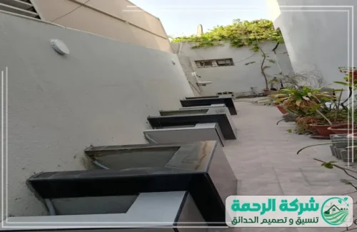 تنسيق حدائق منزلية بالرياض 0559460943 شركة الرحمة ممر خارجي مصمم بعناية يجمع بين العشب الصناعي الأخضر عالي الجودة وبلاطات حجرية للمشي.