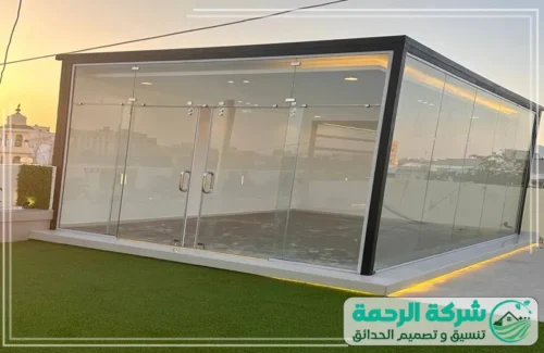 تنسيق حدائق الفلل في الرياض 0559460943 شركة الرحمة منطقة جلوس خارجية مغطاة ببرغولا حديدية سوداء، تتميز بجدار خلفي يدمج بين الخشب والزرع الجداري بتصاميم هندسية